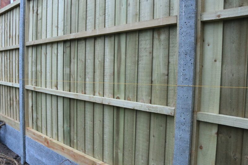 Newly installed close-boarded fence with a concrete post